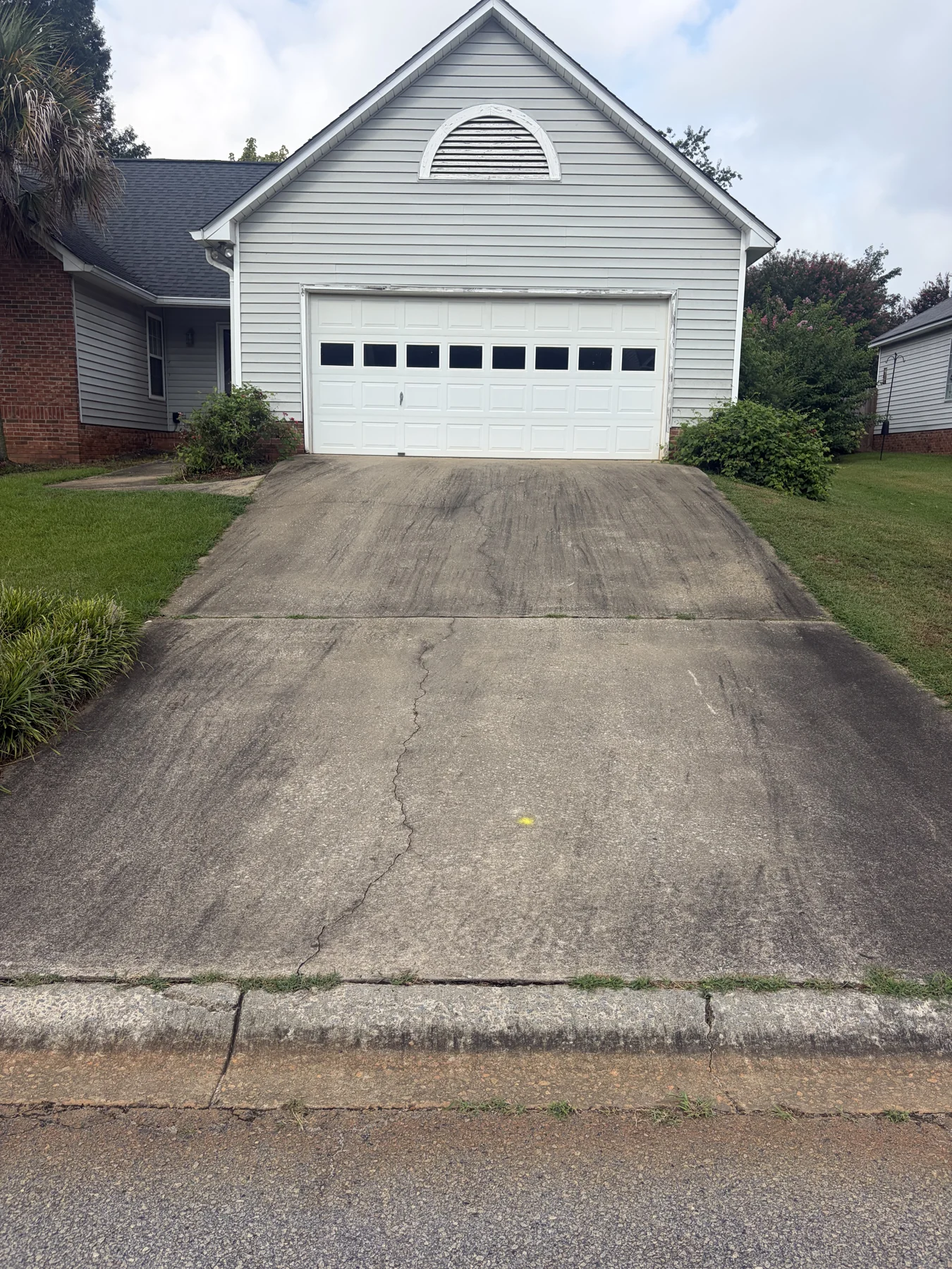 concrete driveway leading to a detached garage before cleaning