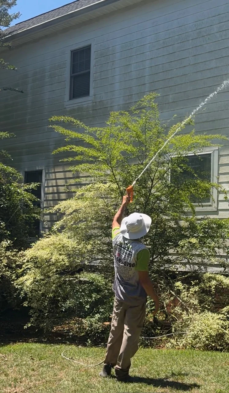 Andrew applying a low-pressure wash to exterior siding