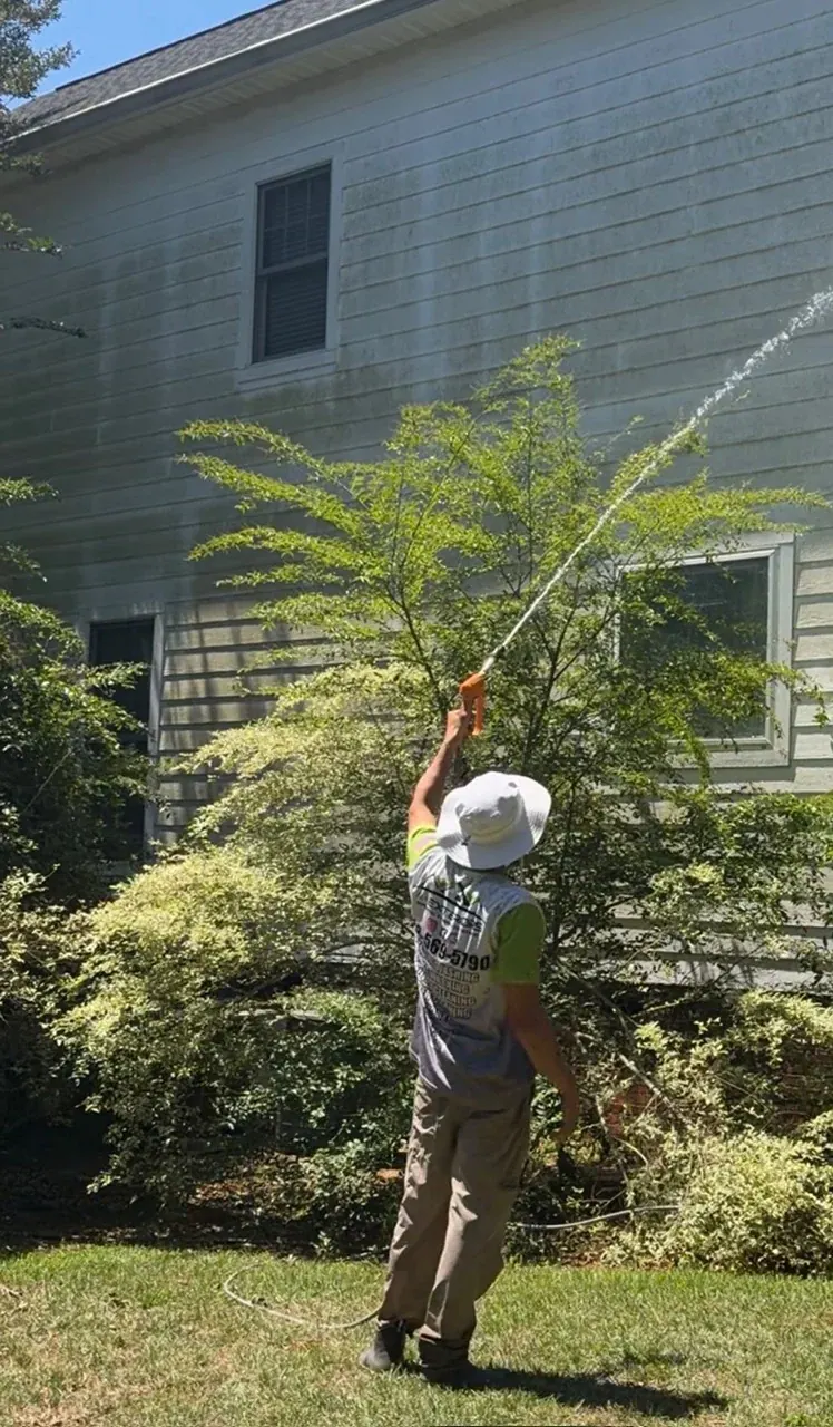 Andrew cleaning the exterior siding of a home